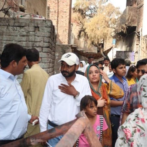 Church leaders listening to a family outside their home