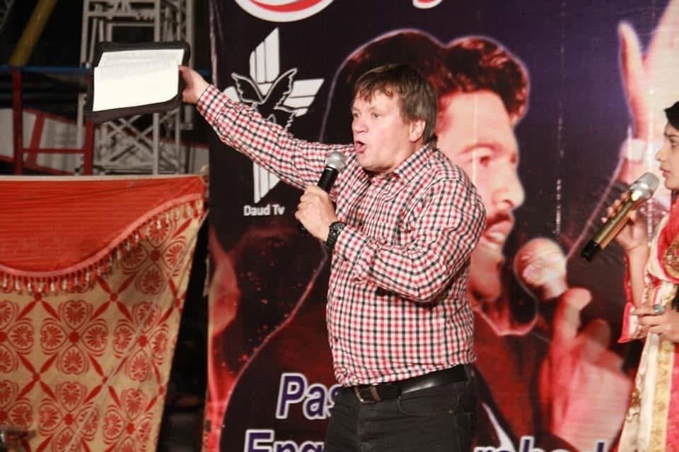 A guest preacher holding up the Bible as he preaches
