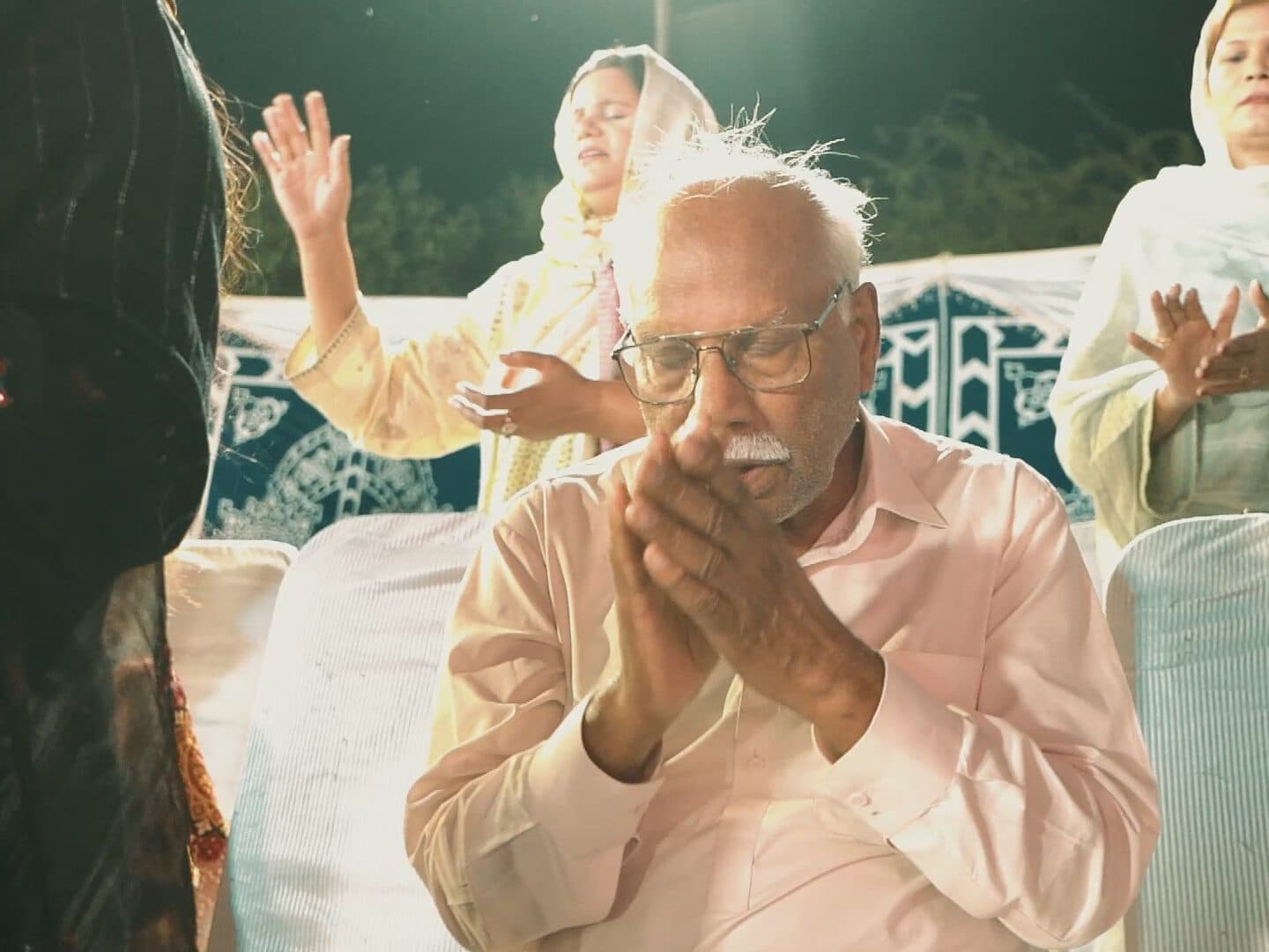 An elder praying with his hands together