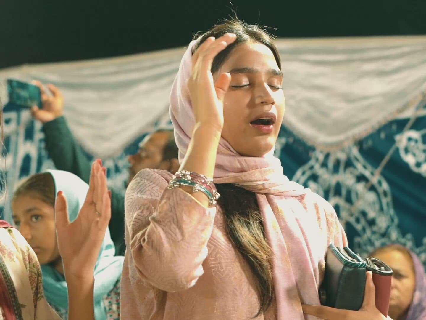 A young woman praying during worship
